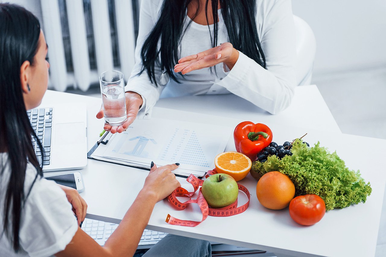 Female nutritionist gives consultation to patient indoors in the office